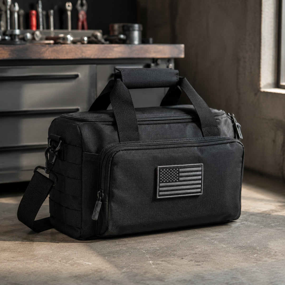 Gun and Utility Bag standing on a garage floor beside a workbench with the shoulder strap attached