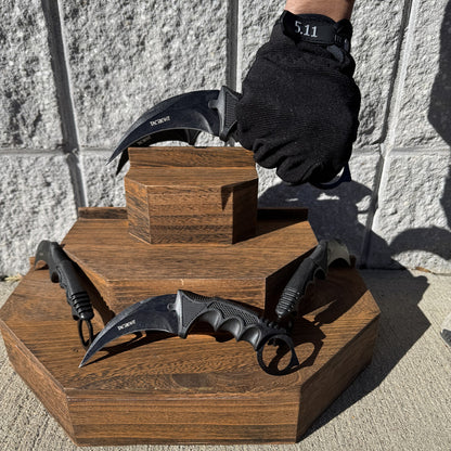 Karambit knife held in a gloved hand