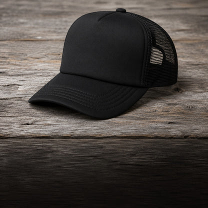 Black trucker cap on barnwood, three-quarter view showing the curved brim and mesh side panel
