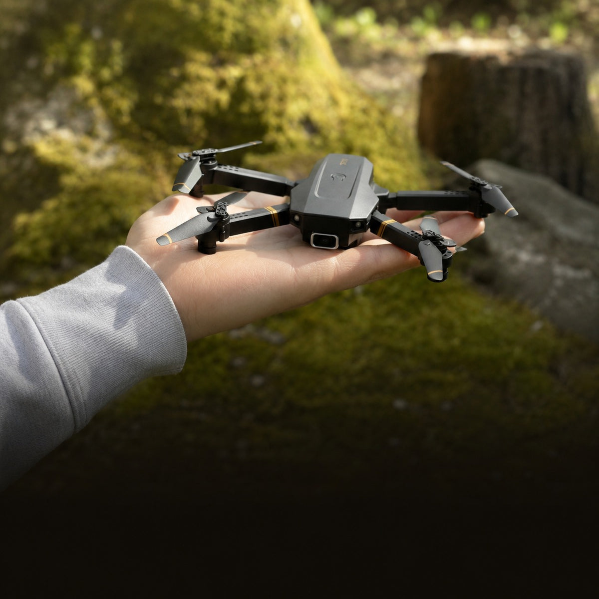 TacRight RC Drone held in one hand with the arms part folded, showing its size