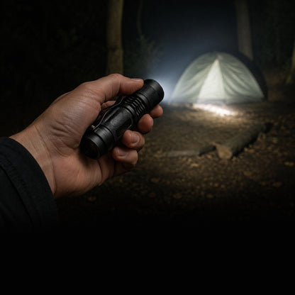 Evatac Flashlight held at a campsite after dark, beam on a tent
