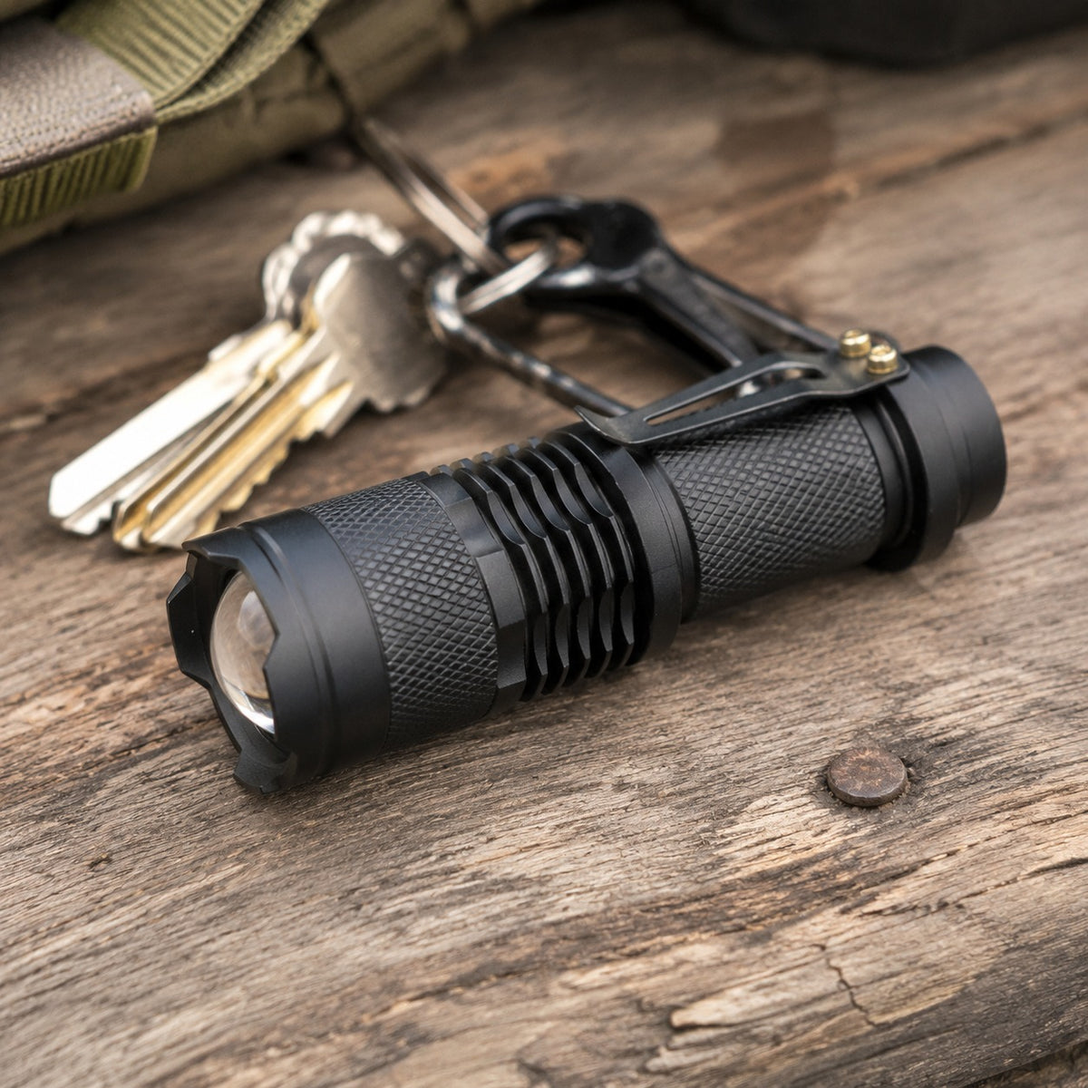 Evatac Flashlight lying on weathered barnwood beside a set of keys, showing its size