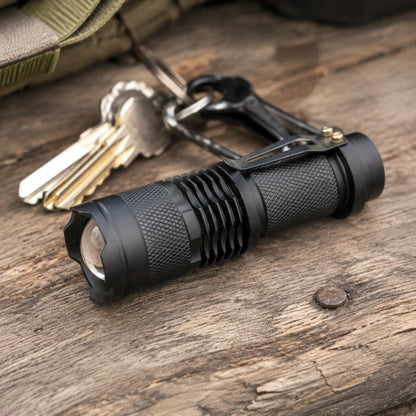 Evatac Flashlight lying on weathered barnwood beside a set of keys, showing its size