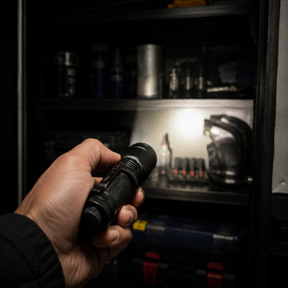 Evatac Flashlight held pointing into a dark tool cupboard, beam on the shelves