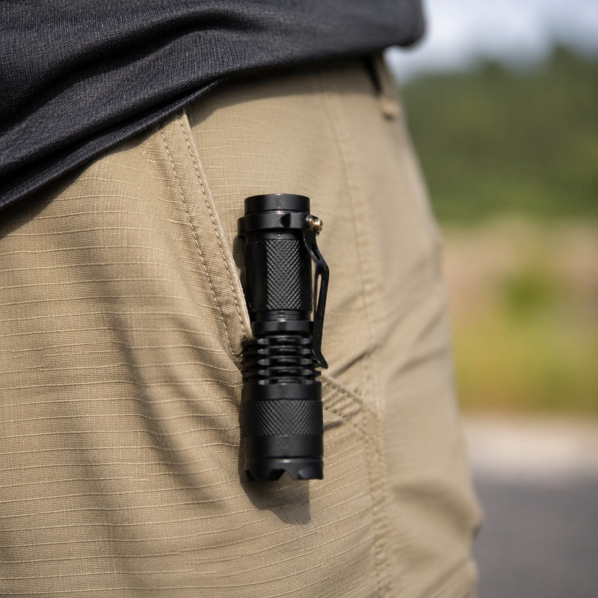 Evatac Flashlight clipped to a trouser pocket, unlit, in daylight