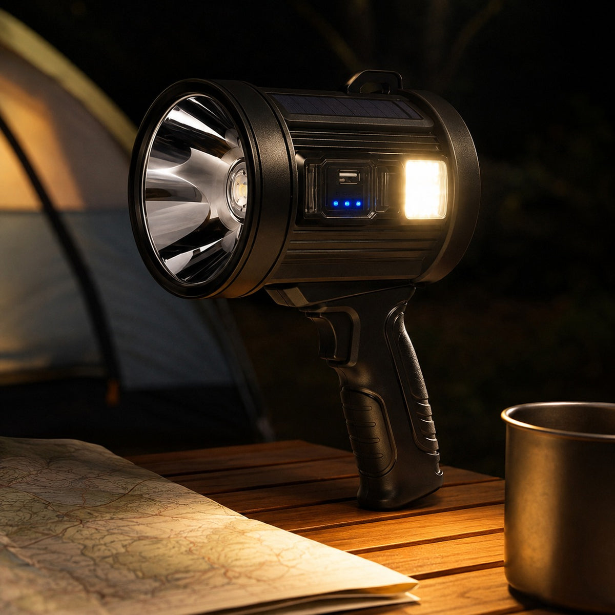 Outdoor Searchlight stood on a camp table with only its side work light on, over a map and a mug
