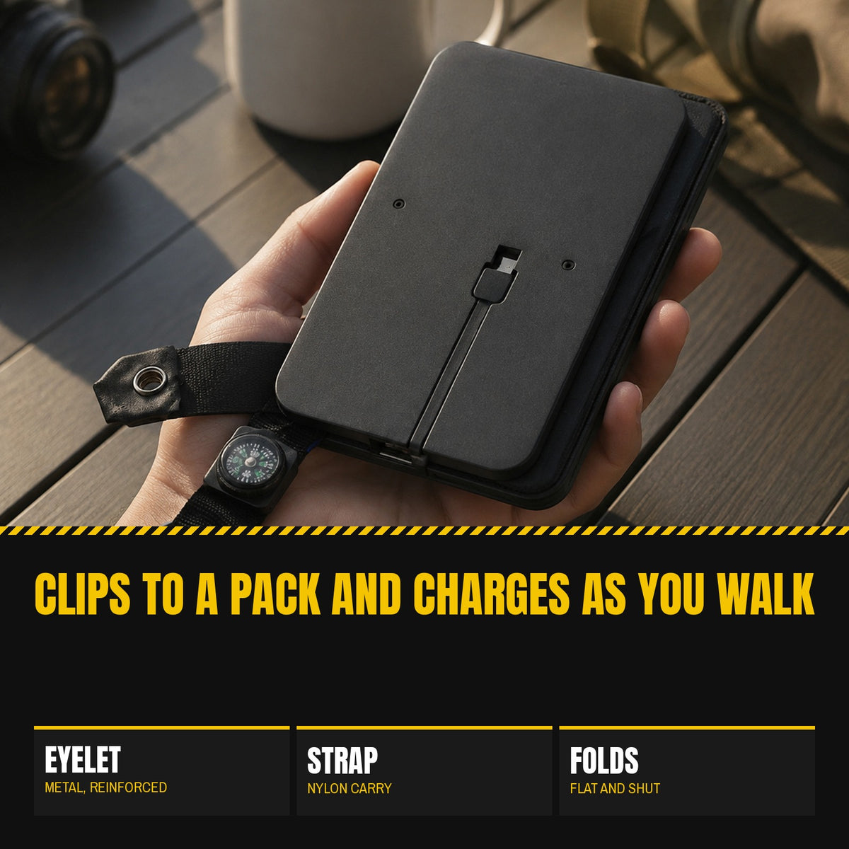 4 Panel Solar Charger folded closed in one hand with the built-in cable in its channel