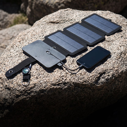 4 Panel Solar Charger unfolded on rock beside a charging phone