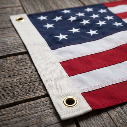 American flag corner on weathered wood, brass grommet and canvas header in focus