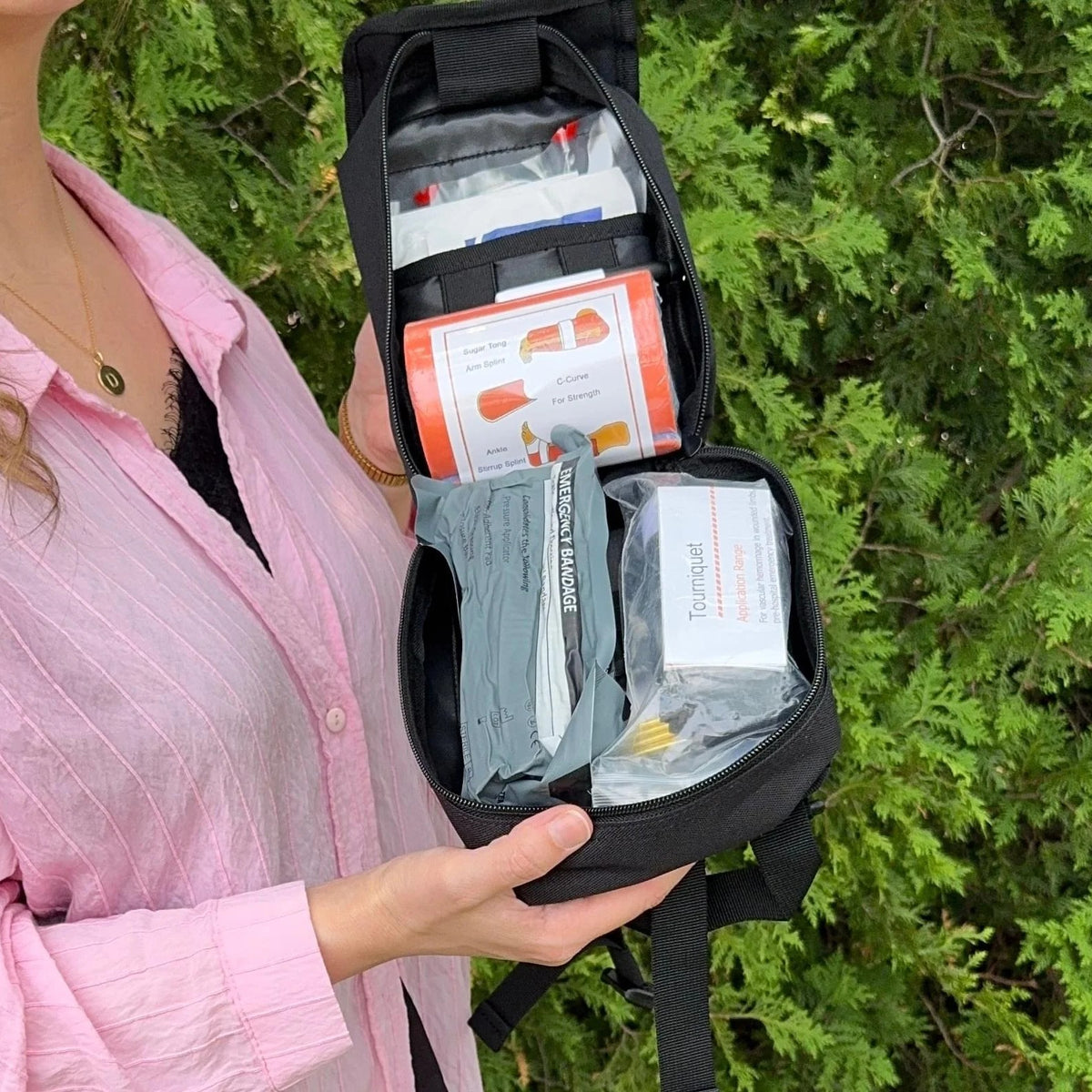 Trauma First Aid Kit held open outdoors with its supplies visible